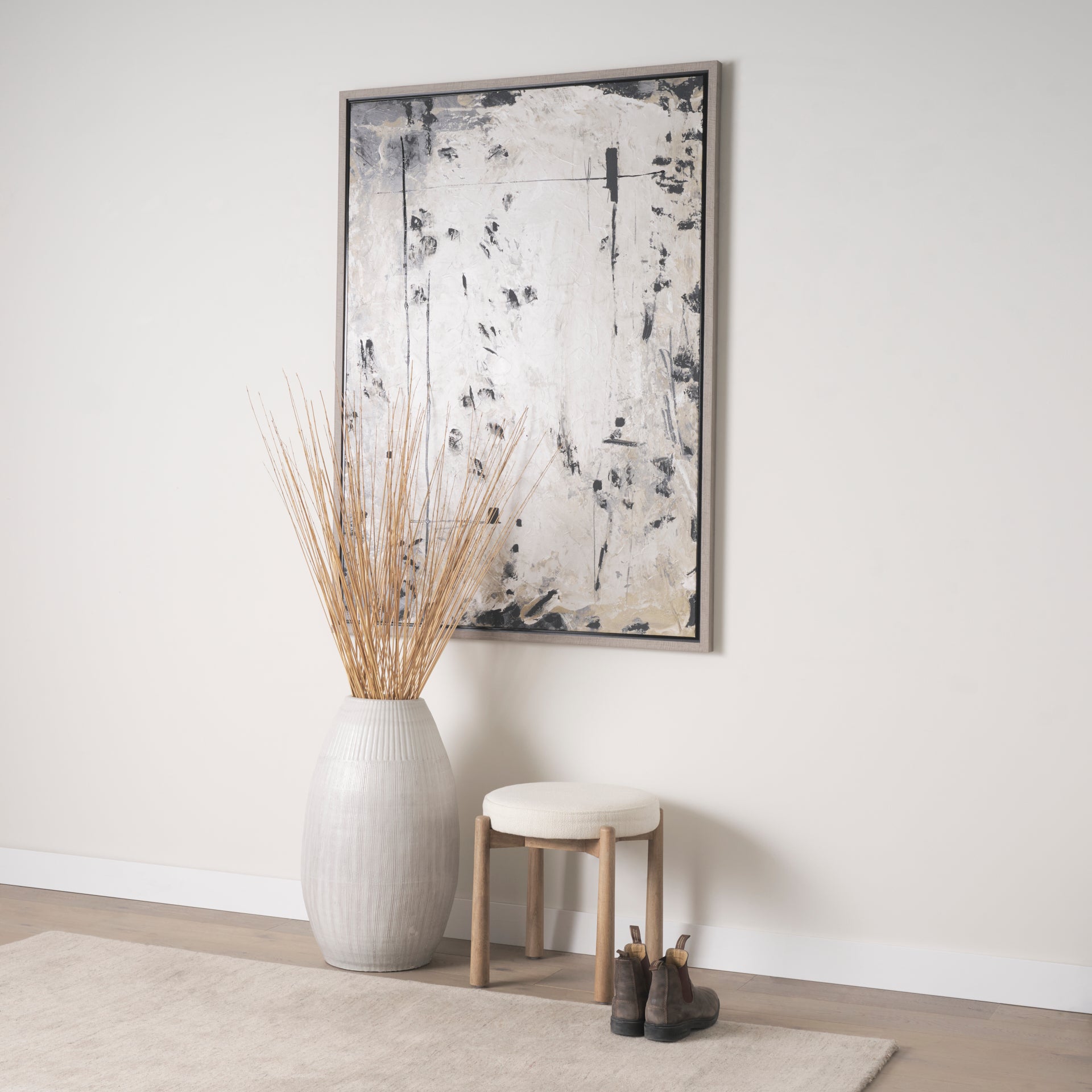 Front three-quarter view of the Shaiden stool featuring a light brown wood frame and a circular cream upholstered seat