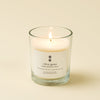 Glass candle with a label on a beige background citrus grove