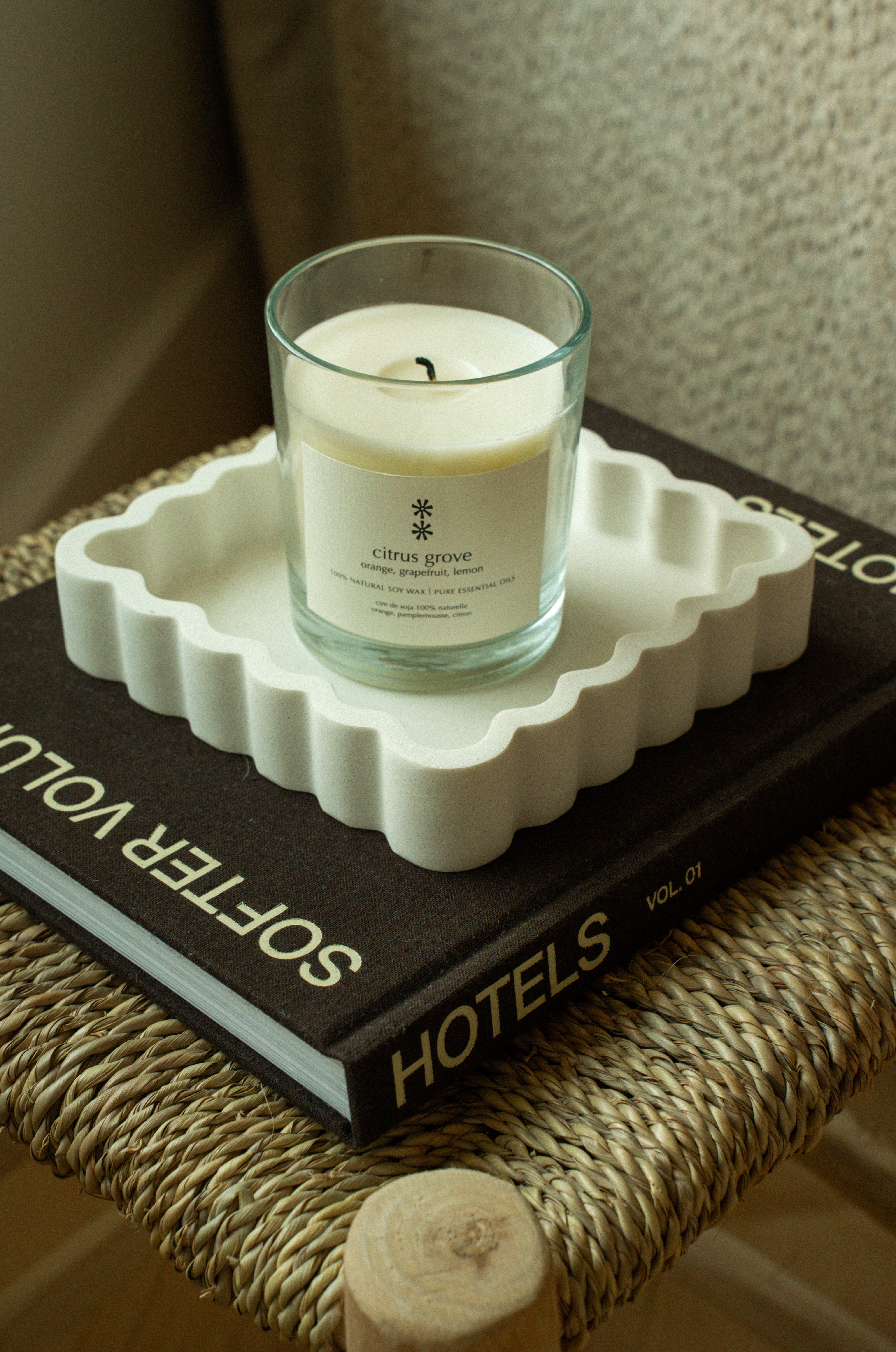 Glass candle with a label on a beige background citrus grove