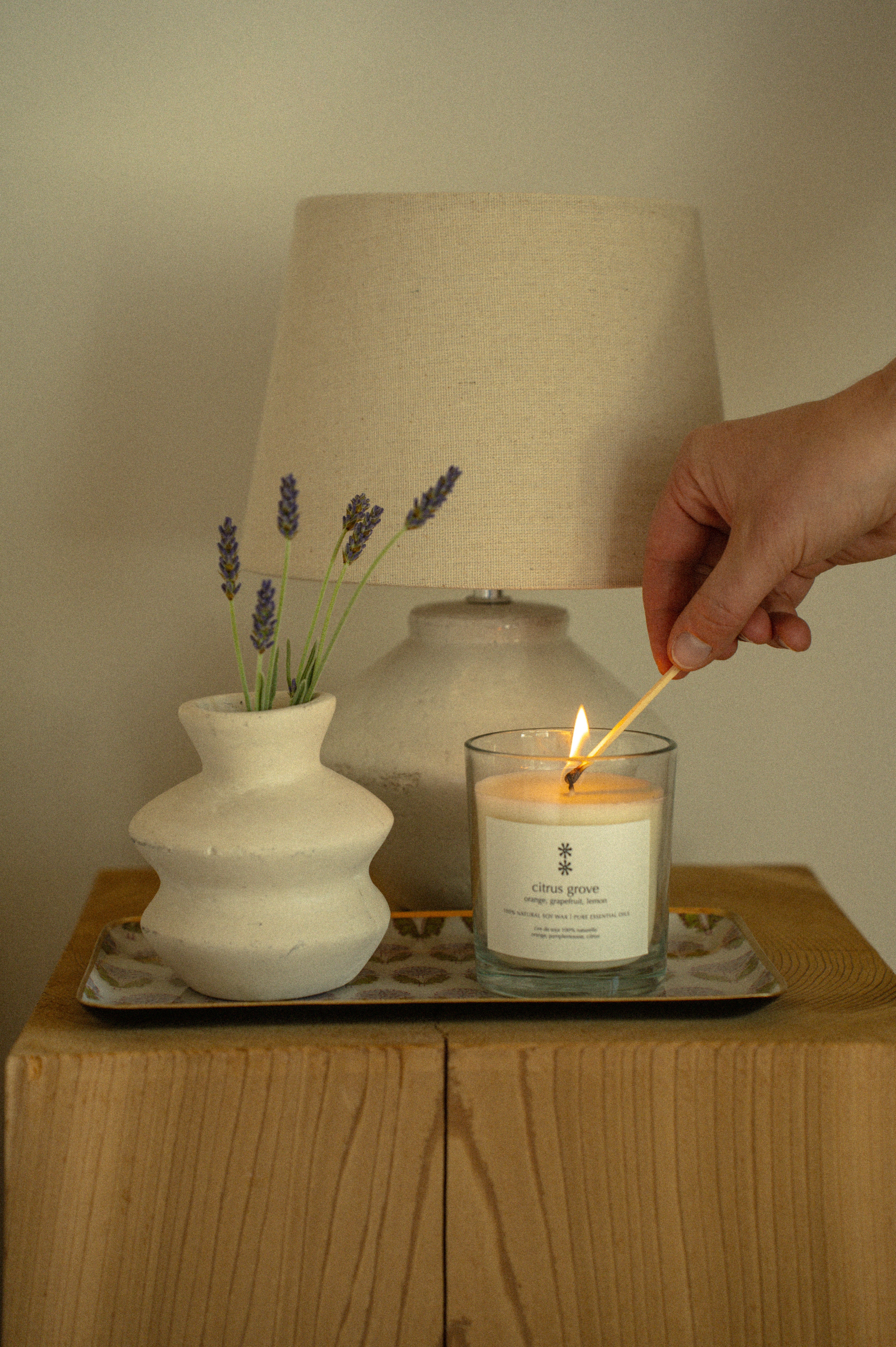 Glass candle with a label on a beige background citrus grove