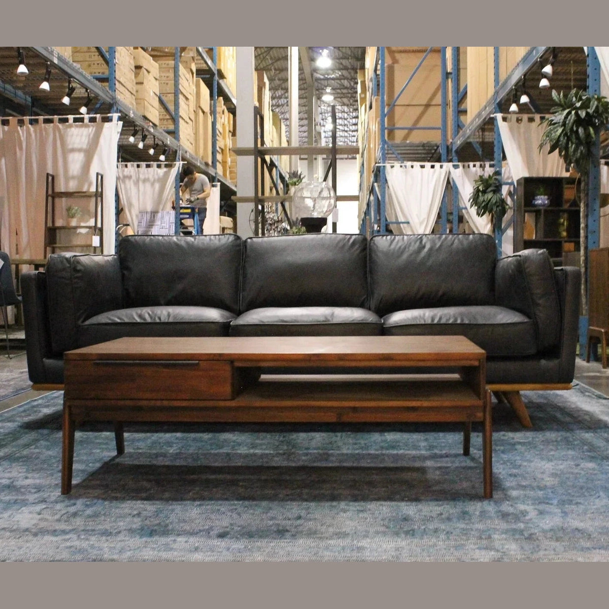 Lifestyle view featuring the Remix coffee table styled in front of a dark leather sofa in a contemporary interior