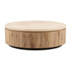 Front view of the Canyon coffee table featuring a circular cream travertine top and a substantial light wood drum pedestal base
