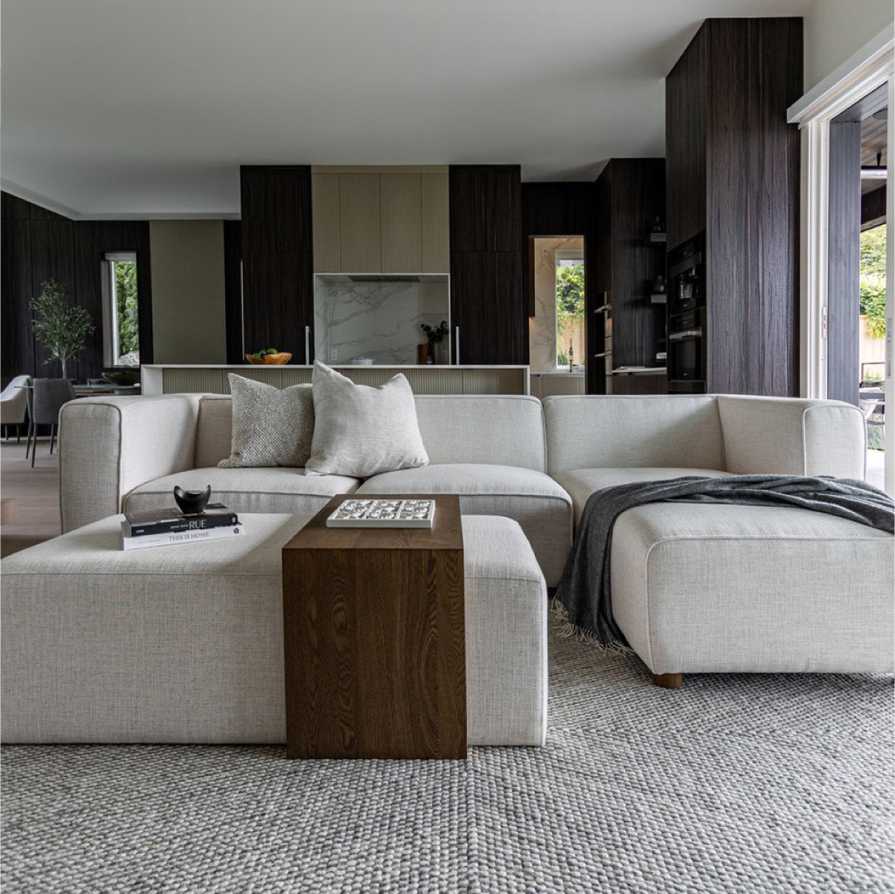 Front view of the Forest coffee ottoman featuring a cream upholstered rectangular bench with a nested blonde oak waterfall table