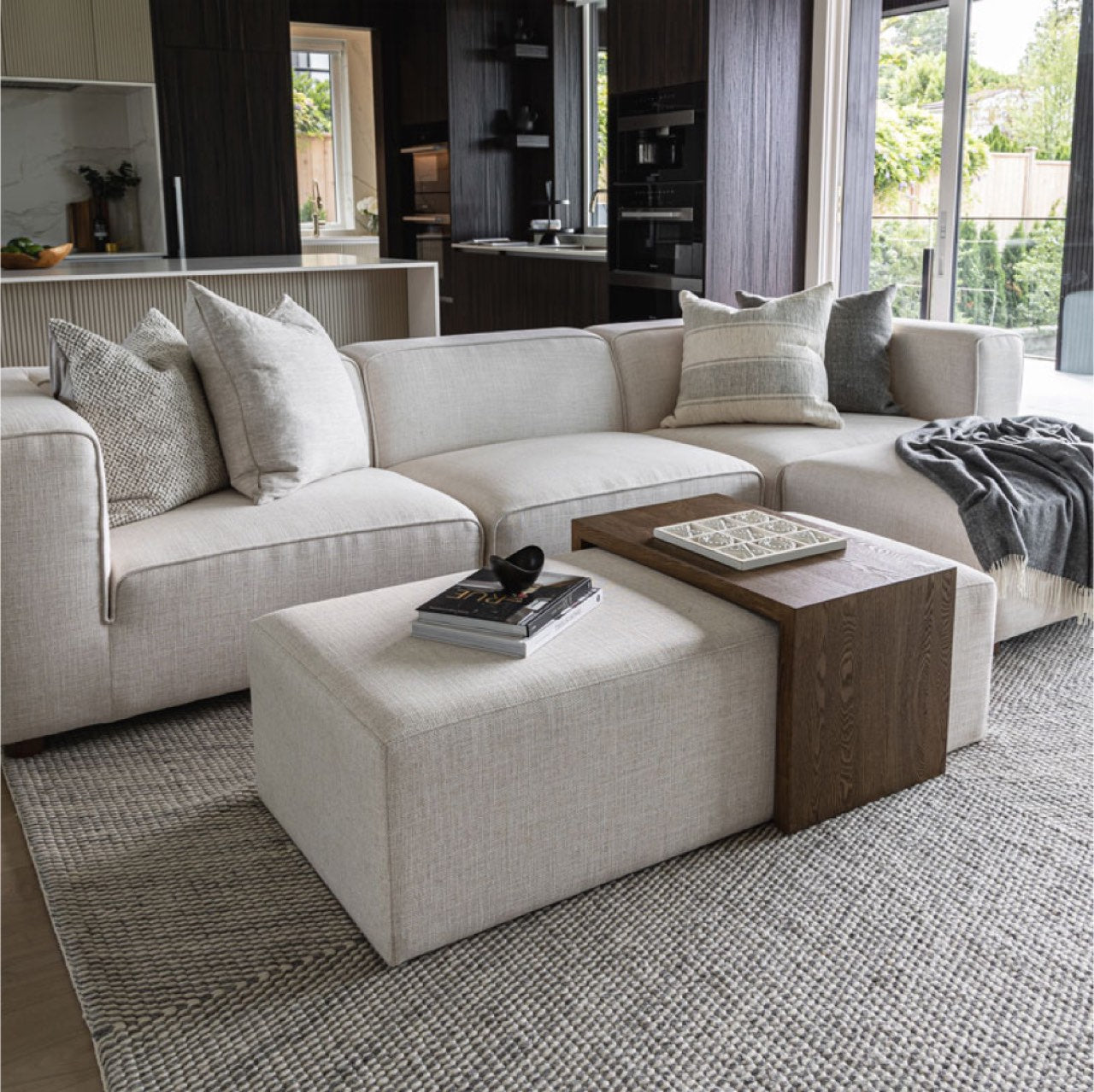 Front view of the Forest coffee ottoman featuring a cream upholstered rectangular bench with a nested blonde oak waterfall table