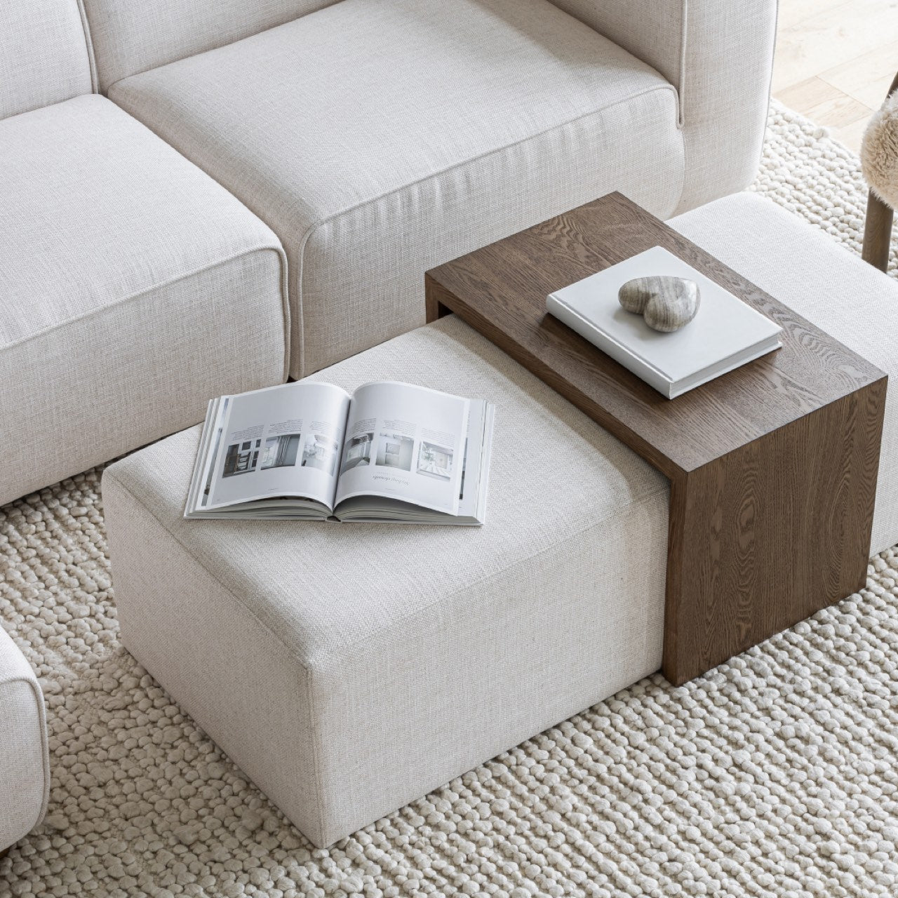 Front view of the Forest coffee ottoman featuring a cream upholstered rectangular bench with a nested blonde oak waterfall table