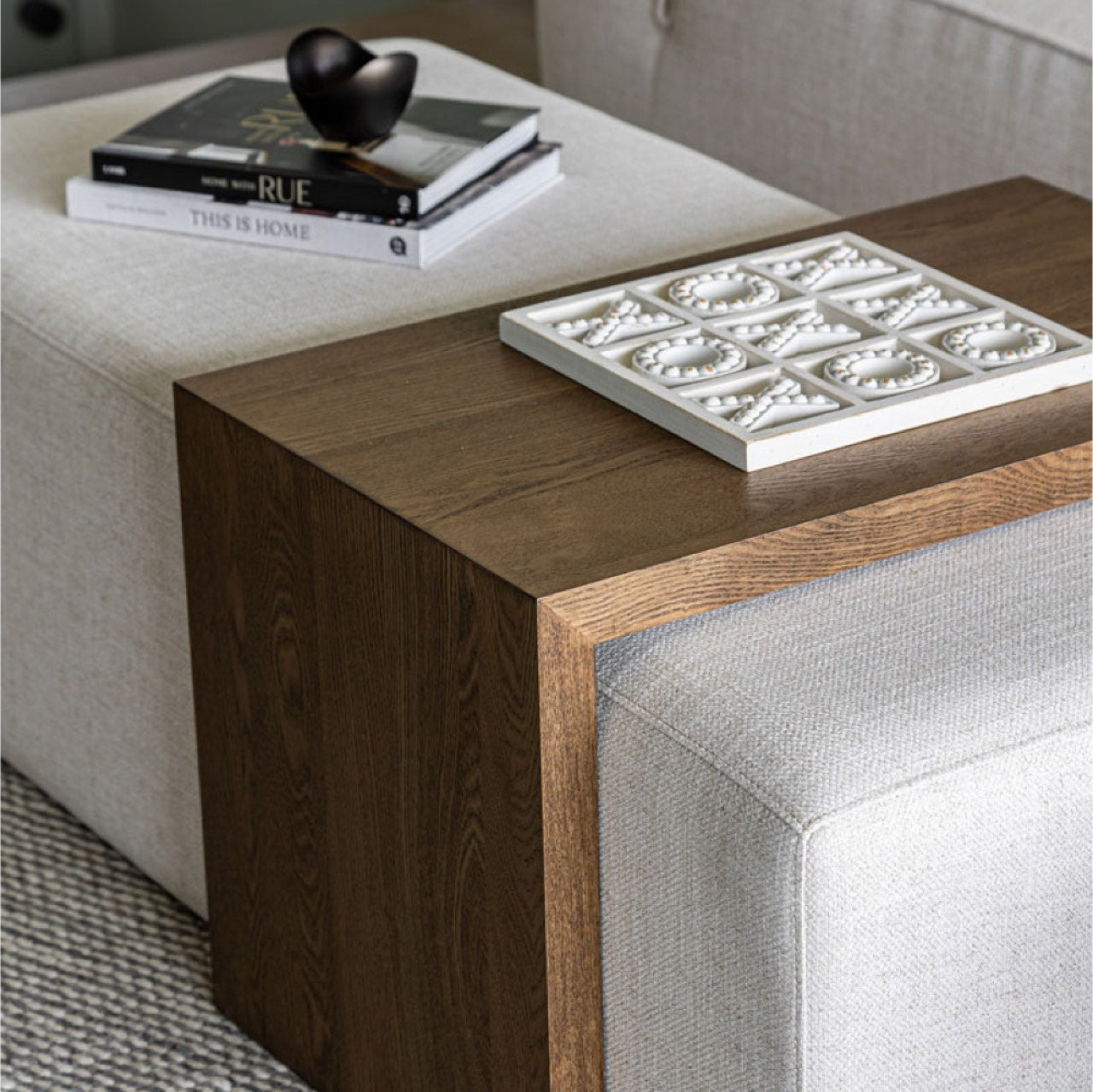 Front view of the Forest coffee ottoman featuring a cream upholstered rectangular bench with a nested blonde oak waterfall table