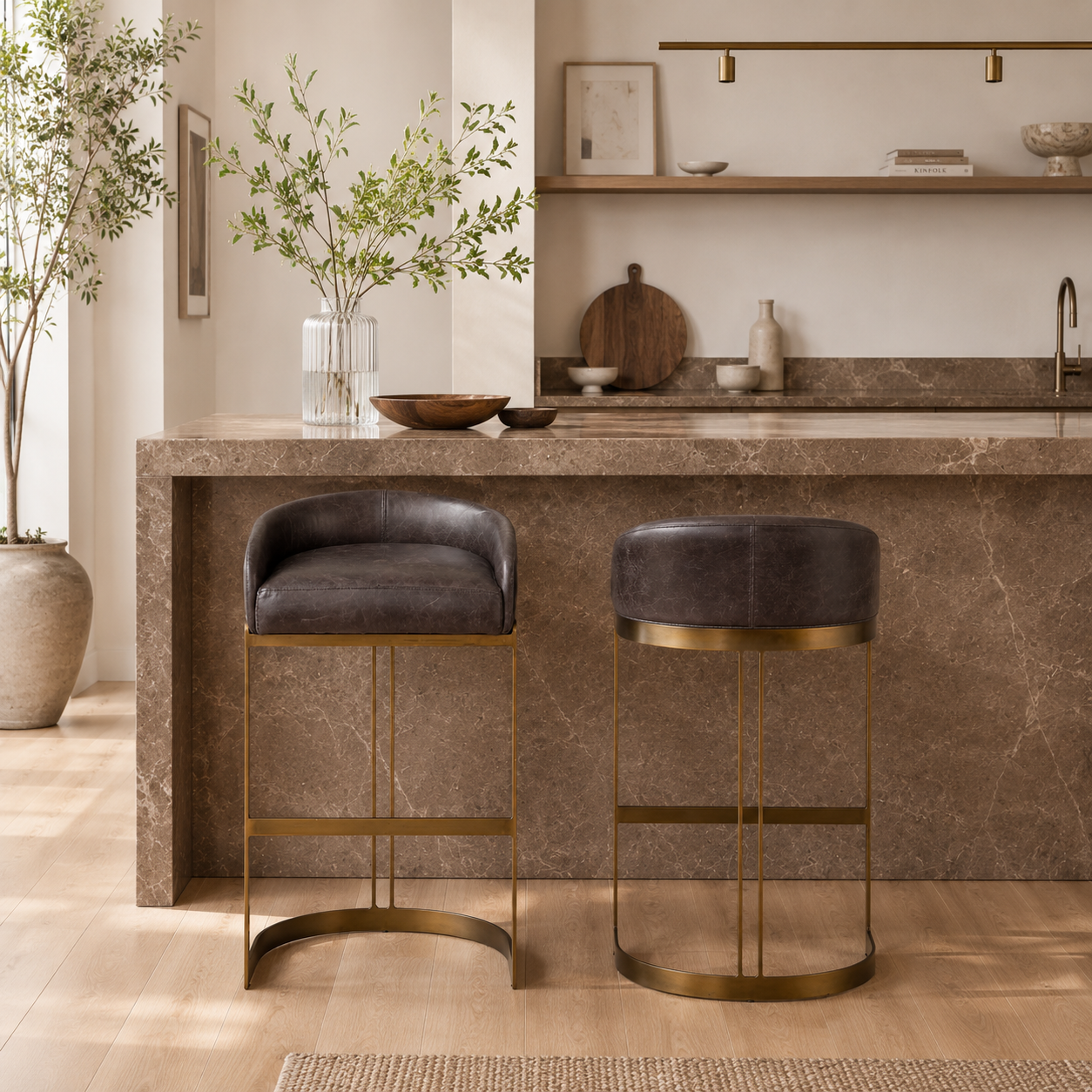 A modern bar stool featuring a curved brown leather seat cushion and backrest, supported by a slim gold-finished metal frame with a curved base, shown against a plain white background.