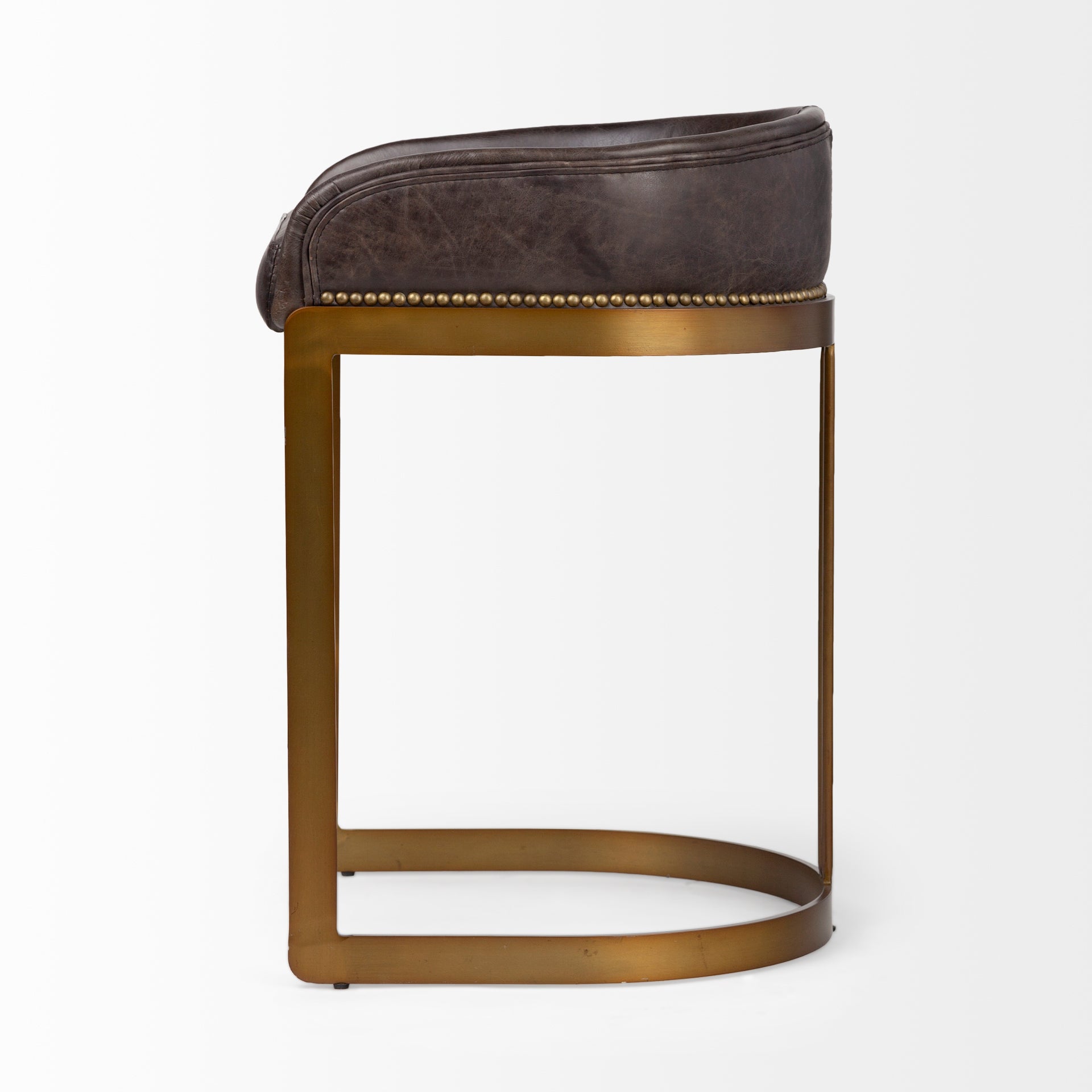 A modern bar stool featuring a curved brown leather seat cushion and backrest, supported by a slim gold-finished metal frame with a curved base, shown against a plain white background.