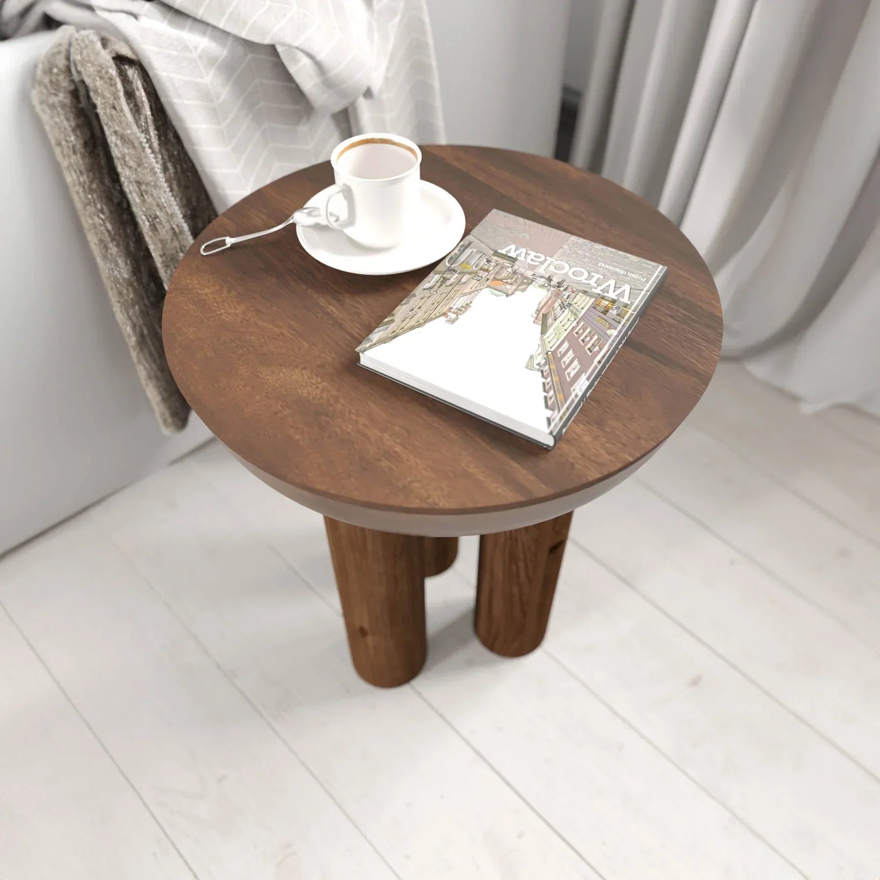 Lifestyle view of the Wilder table styled as a minimalist nightstand in a bright bedroom setting next to a white bed