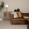 Camel brown Channel sofa styled in a warm, modern living room
