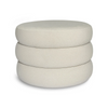 Front view of the Siel round ottoman featuring a unique triple-stacked design upholstered in soft sand-colored velvet