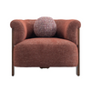 Front view of the Stave accent chair in rust-toned bouclé fabric with a dark walnut wood frame and a spherical lumbar pillow