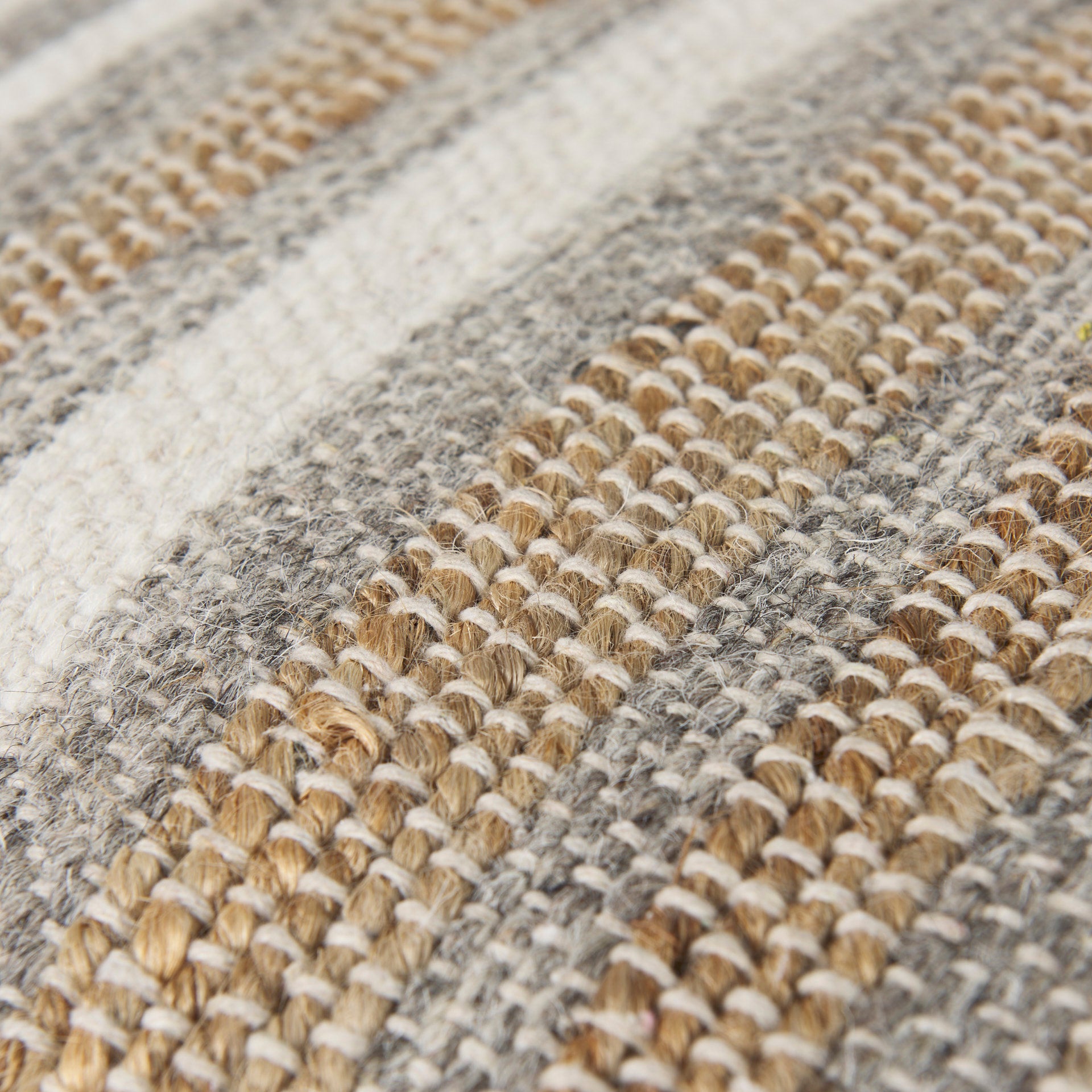 Elevated angled view showcasing the uniform striped pattern across the top and sides of the woven ottoman
