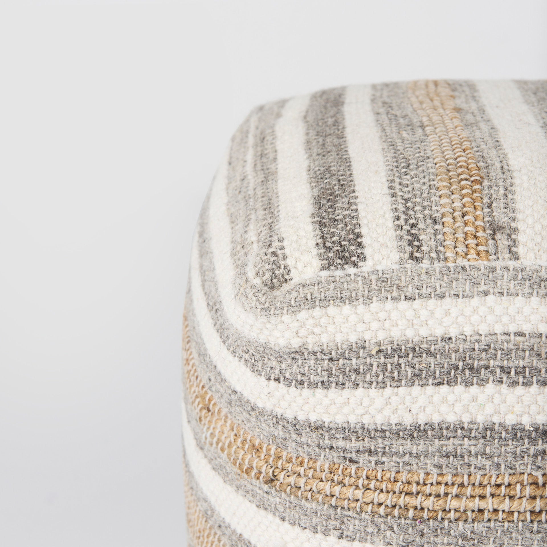 Elevated angled view showcasing the uniform striped pattern across the top and sides of the woven ottoman