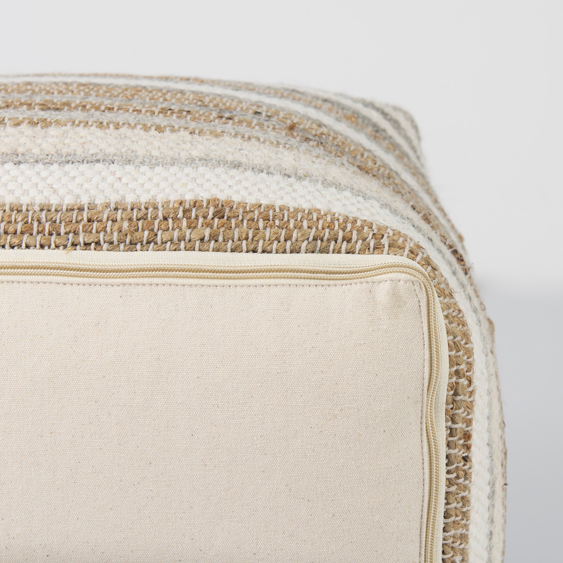 Elevated angled view showcasing the uniform striped pattern across the top and sides of the woven ottoman