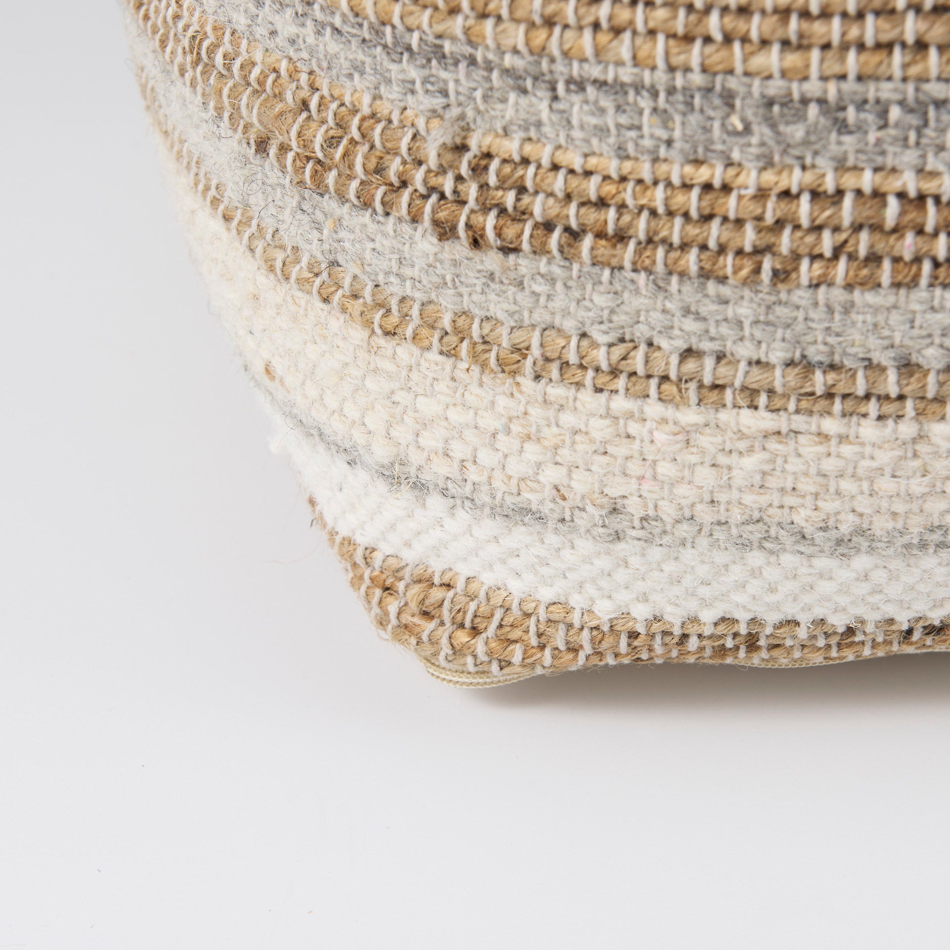 Elevated angled view showcasing the uniform striped pattern across the top and sides of the woven ottoman