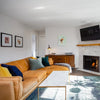 Wide-angle lifestyle shot showcasing the sideboard's scale in a living room setting with a fireplace and large TV