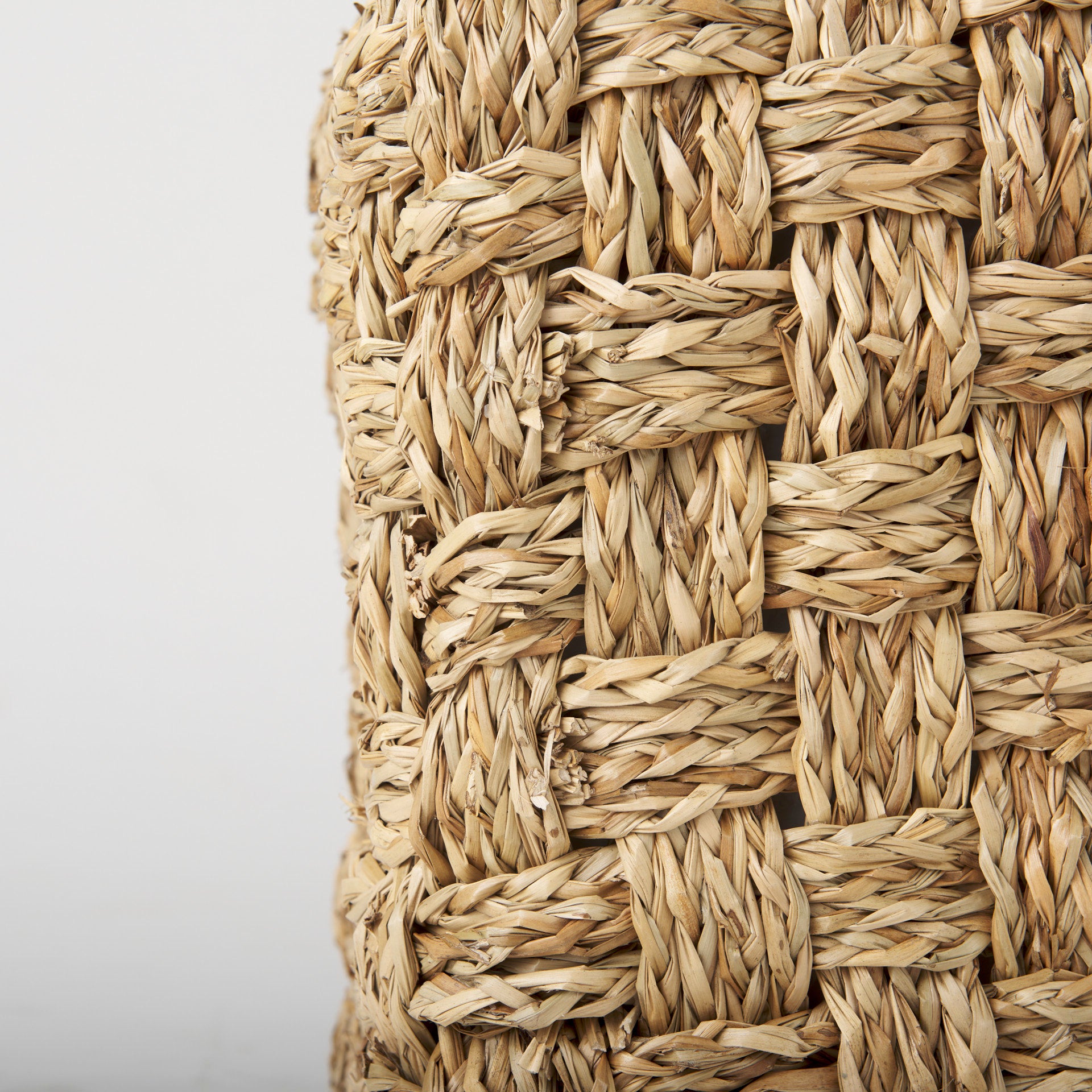 High-angled perspective showcasing the uniform square silhouette and handcrafted texture of the seagrass pouf