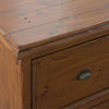 Macro shot focusing on the rustic pine wood grain and the hand-finished edges of the cabinet top