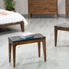 Lifestyle shot featuring the Allure table styled as a low bench or accent piece in a modern bedroom setting