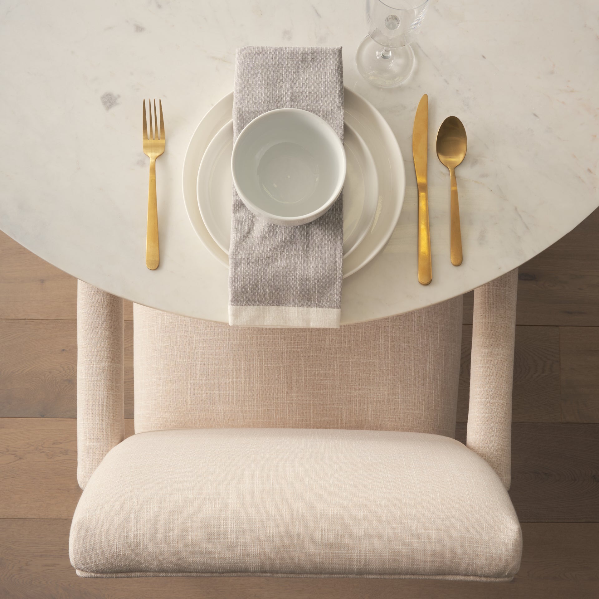 Front view of the Allyson round dining table featuring a white marble top and a solid mango wood tapered pedestal base
