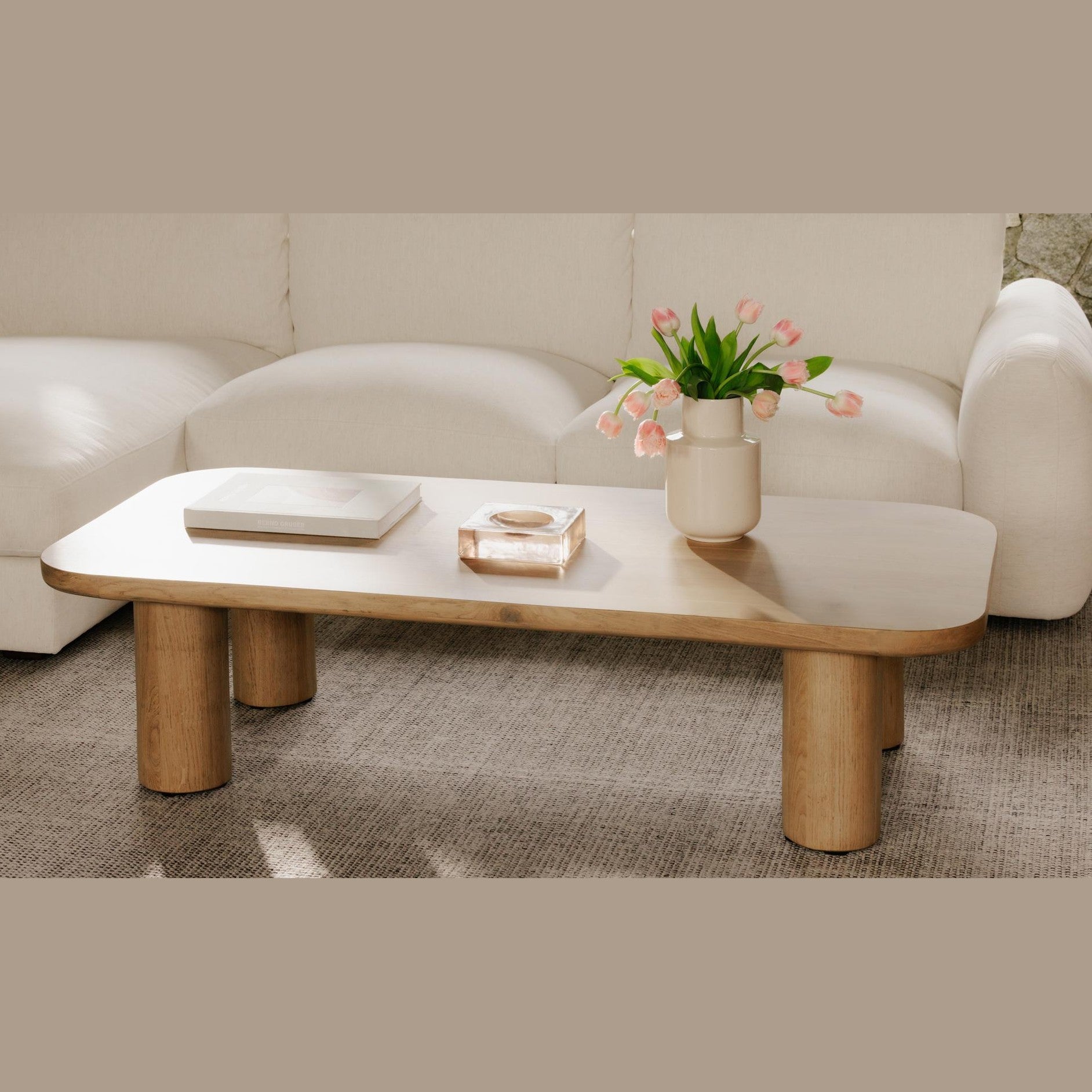 Lifestyle shot of the Anders coffee table styled with a white vase and tulips in a bright modern living room
