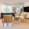 Wide lifestyle view showing the table as a decorative accent in a contemporary space with a dark patterned sofa