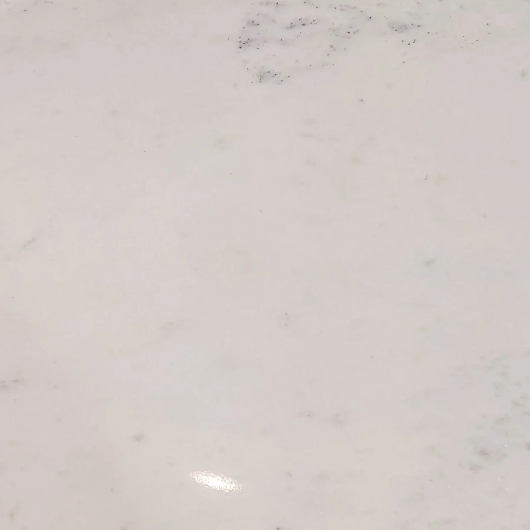Macro shot focusing on the soft grey natural veining and polished finish of the authentic white marble surface
