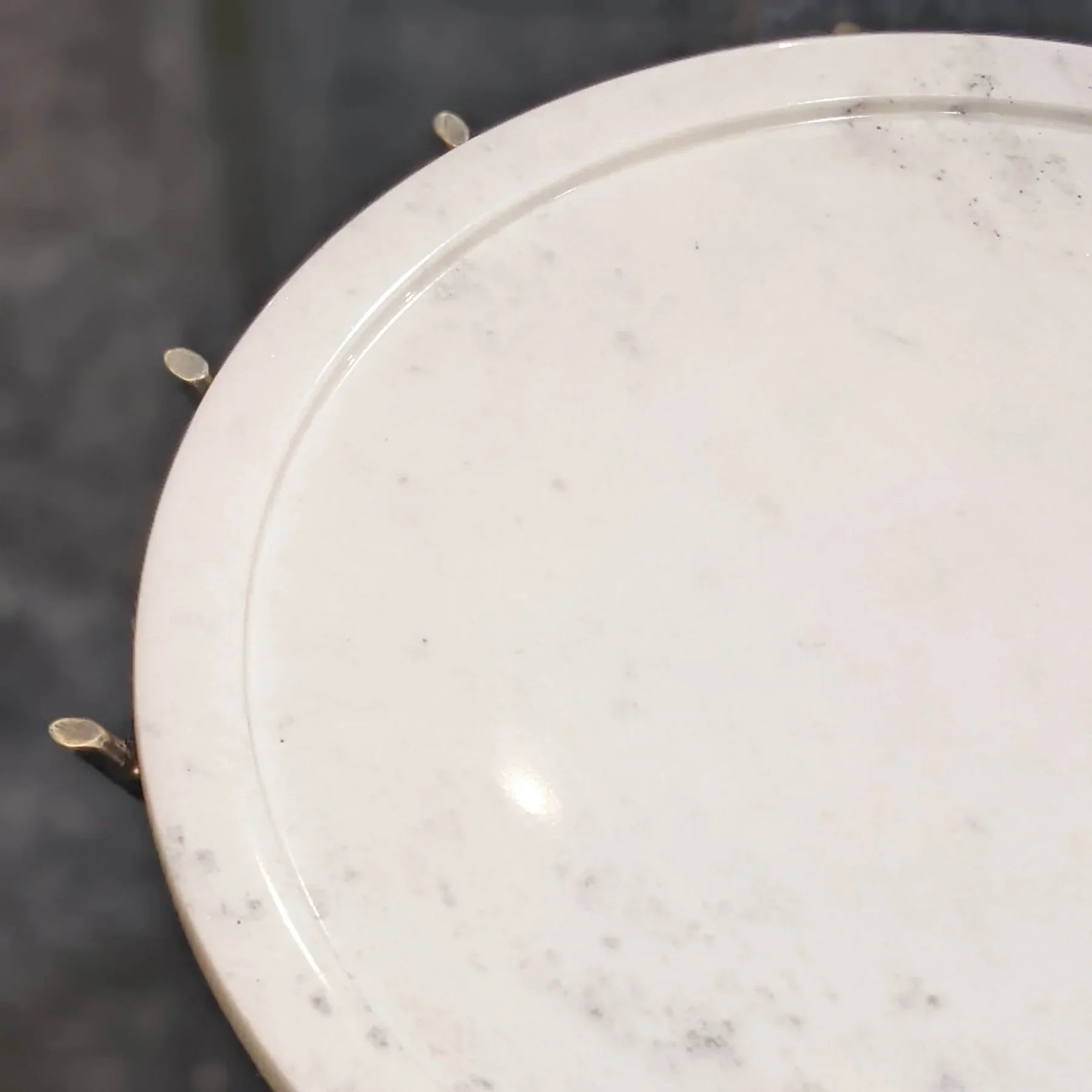 High-angle detail shot showcasing how the gold metal rods support the circular white marble tabletop