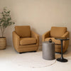 Pair of caramel Baltimo club chairs styled in a minimalist room with a stone side table