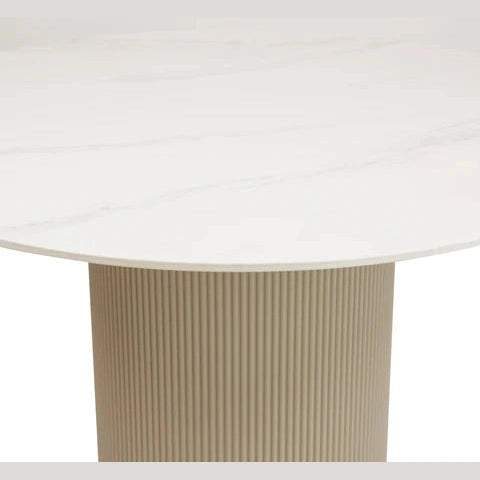 Front view of the Rune round dining table featuring a white marble tabletop with grey veining and a beige fluted cylindrical pedestal base