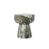 Three-quarter view of the Binx side table featuring a sculptural hourglass silhouette crafted from forest green marble with dramatic swirling veining