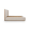 Side view silhouette focusing on the low-profile design and the warm natural wood plinth base that anchors the upholstered frame