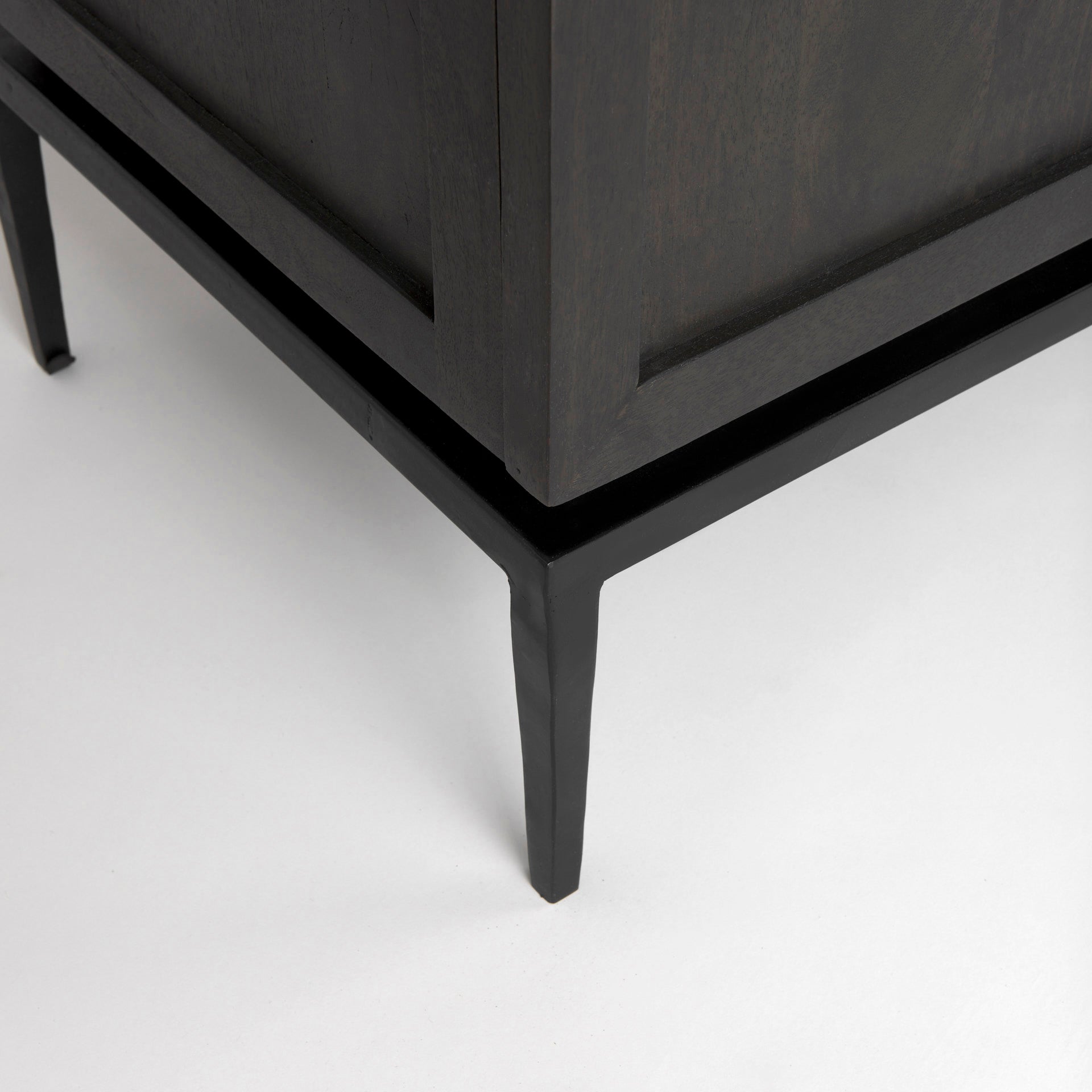 Front perspective view of the Gemma sideboard featuring a dark charcoal wood finish, a white marble top, and slim black metal legs
