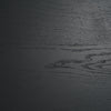 Macro shot focusing on the deep tactile wood grain and matte black finish of the oak door panels