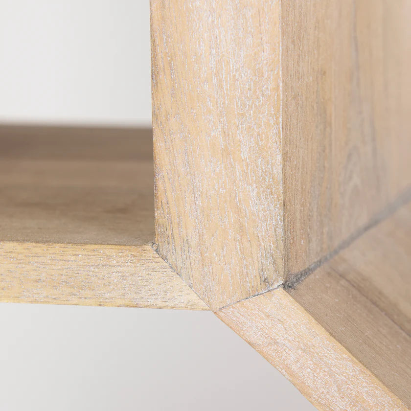 Three-quarter perspective view of the Traro shelving unit in blonde wood featuring a unique geometric honeycomb compartment design