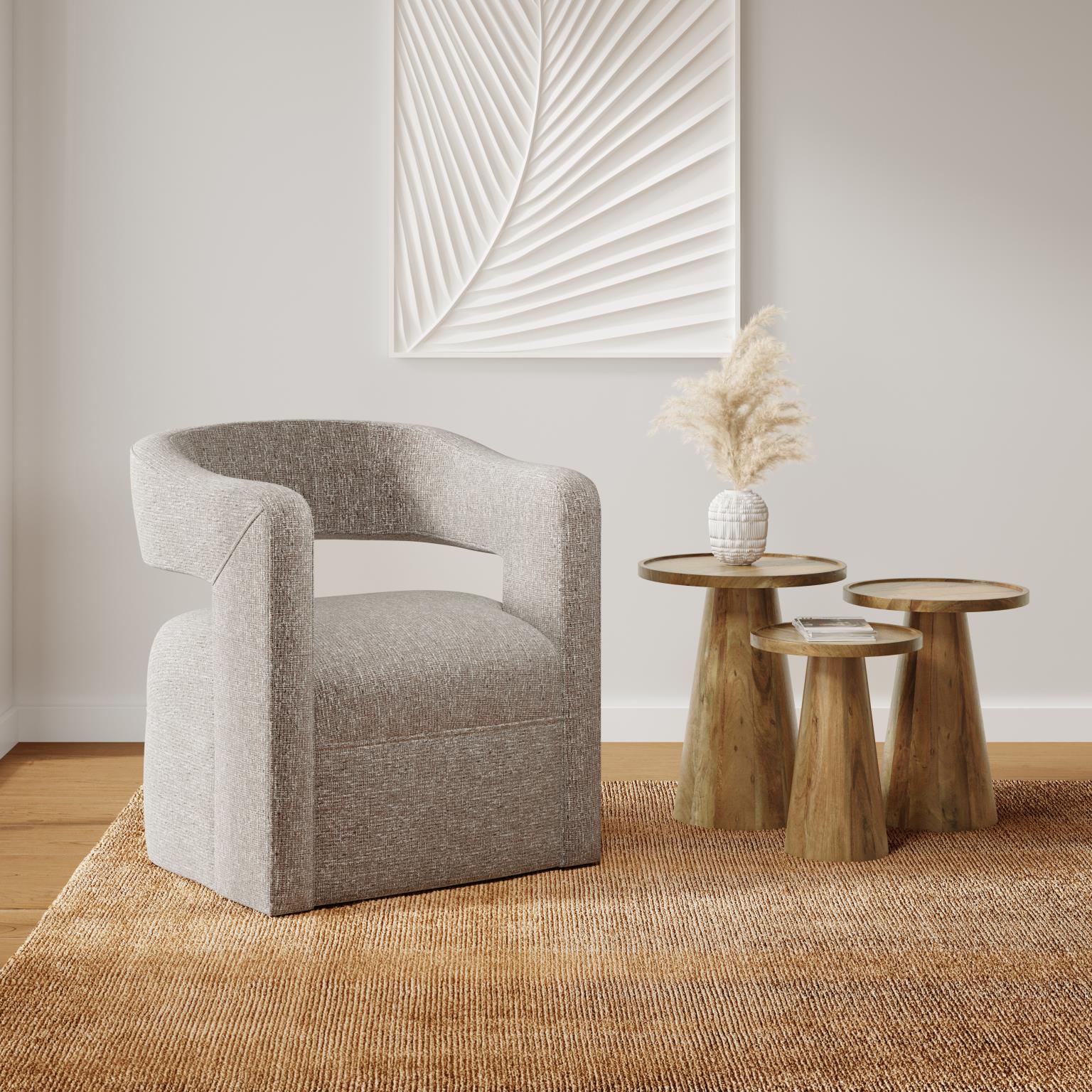 Lifestyle shot featuring the Bo tables styled in a contemporary interior next to a textured grey armchair and neutral rug
