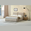 Lifestyle shot showcasing the bed styled with layered neutral bedding and a modern wood bedside table