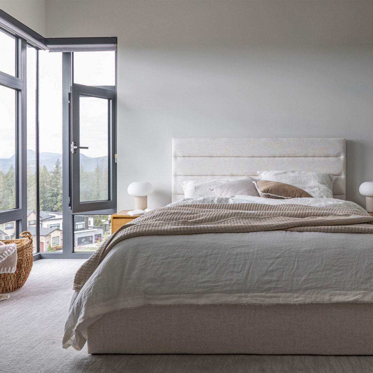 Wide-angle lifestyle shot showing the Justin bed as the central focal point in a bright, modern master suite