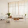 Wide lifestyle view of the natural Bungalow table in a spacious contemporary room with white seating and light-filled windows