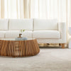 Lifestyle shot featuring the natural slatted coffee table in a bright living room with a white sofa and neutral rug