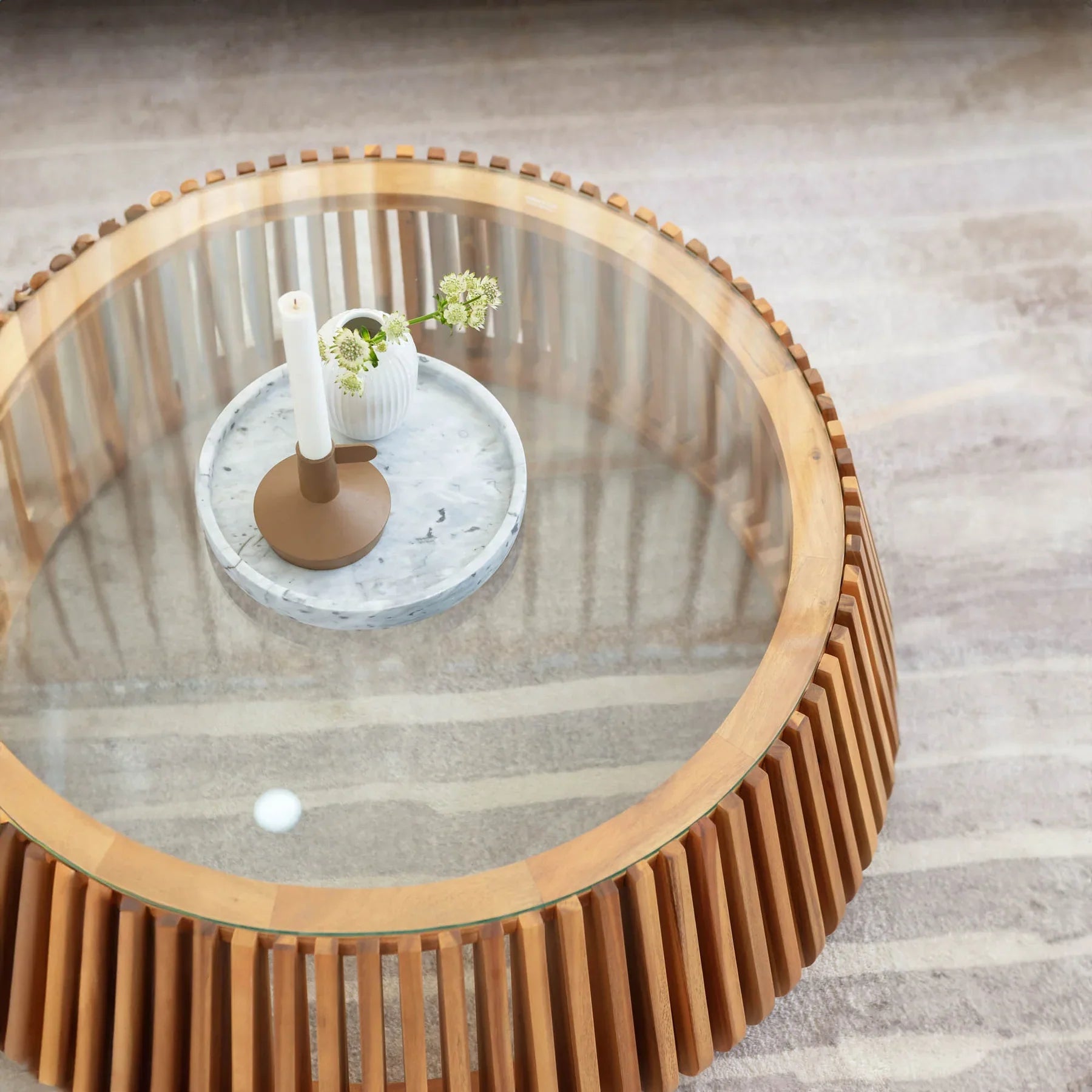 Direct overhead view of the Bungalow coffee table styled with a candle and small plant on the clear glass surface