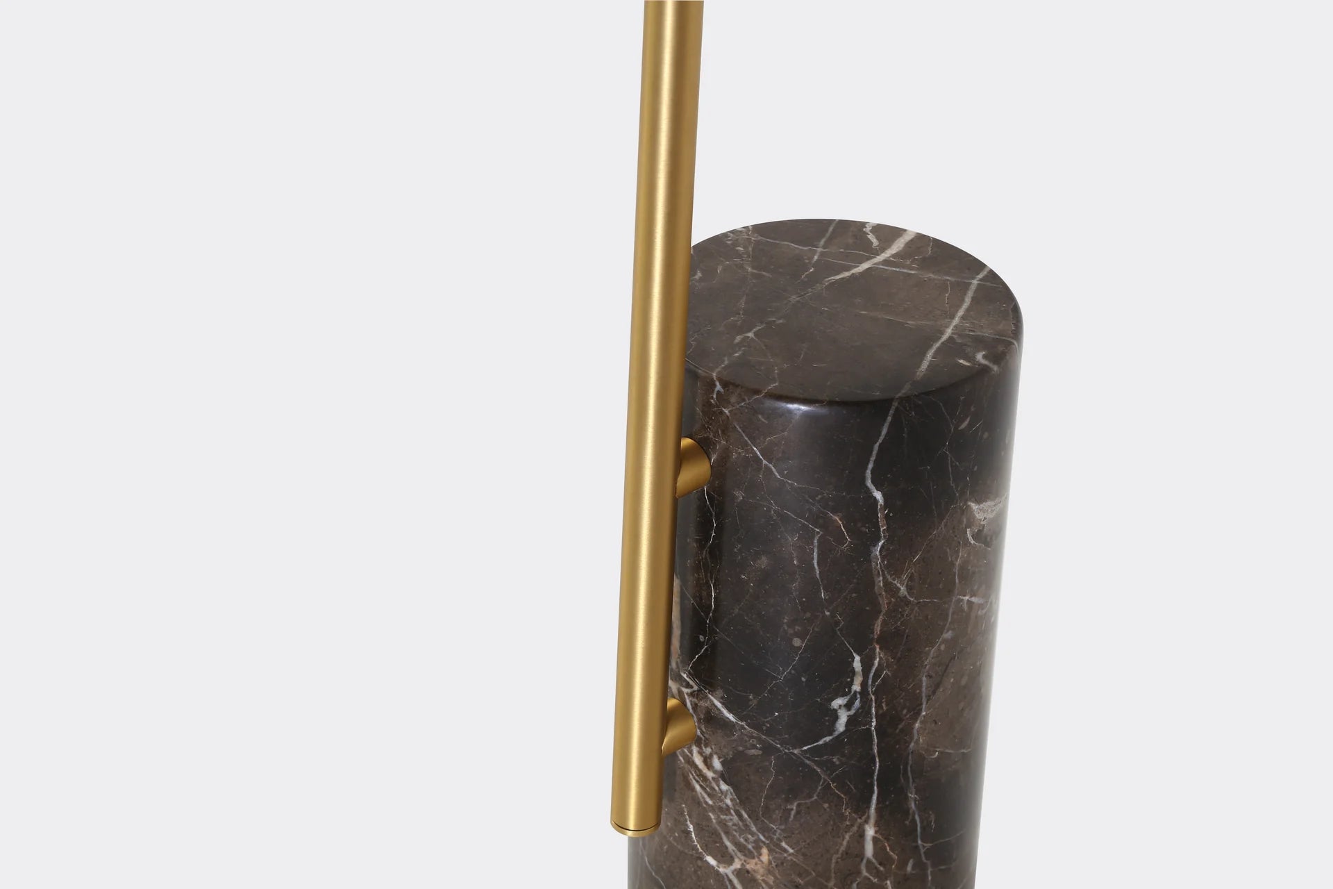 Front view of the Butler end table featuring a circular brushed brass tabletop and a dark marble cylindrical pedestal base