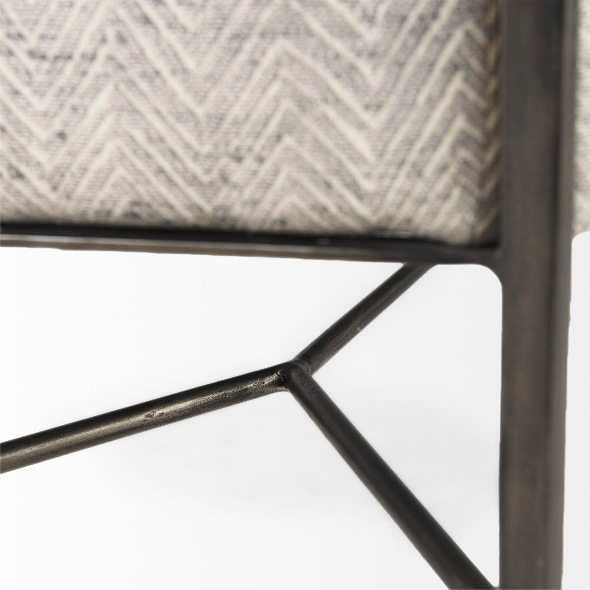 Front view of the Charlotte bench featuring light gray chevron-patterned upholstery and a minimalist black metal frame