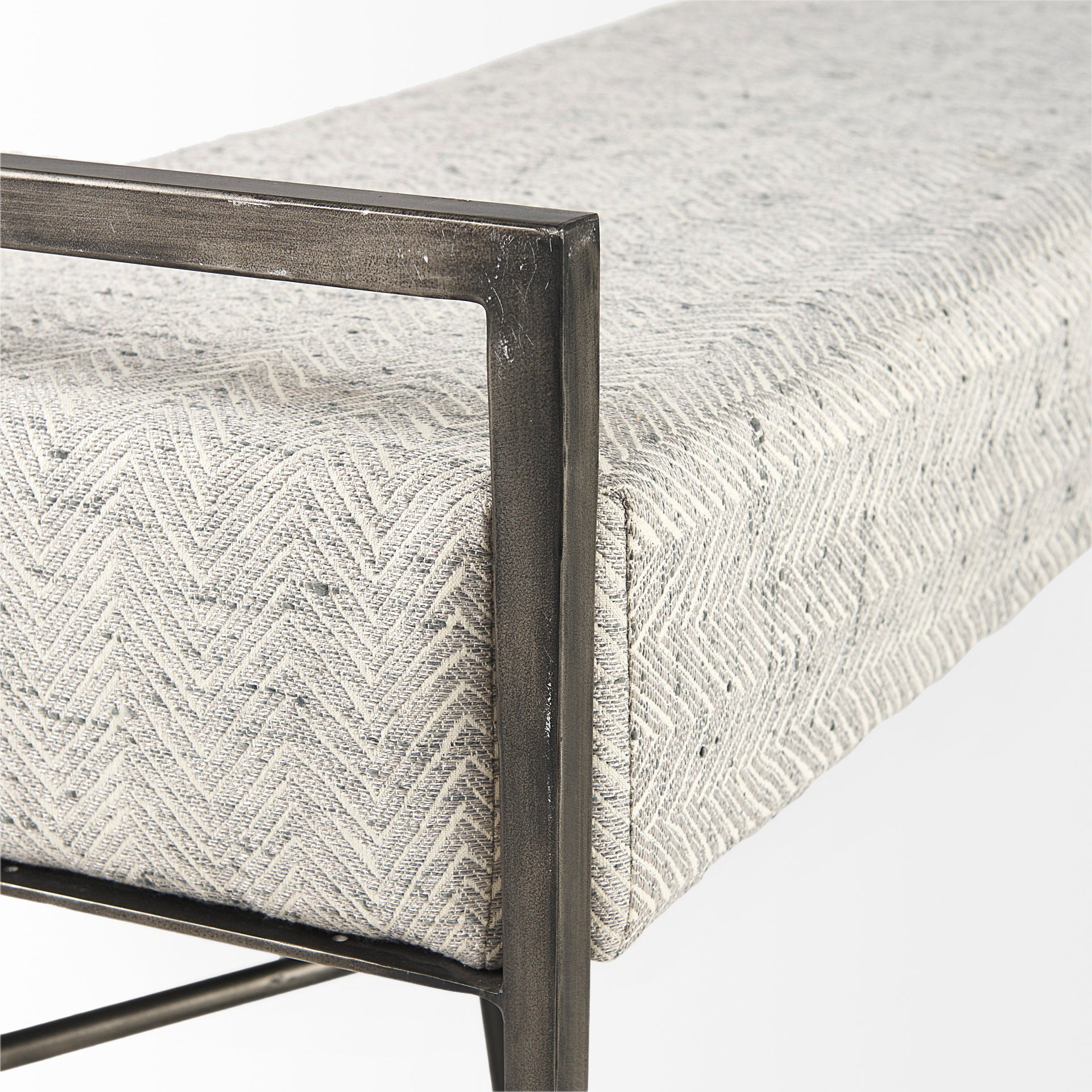 Front view of the Charlotte bench featuring light gray chevron-patterned upholstery and a minimalist black metal frame