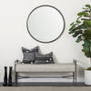 Lifestyle shot of the Charlotte bench styled in a minimalist entryway with a round wall mirror and indoor plant