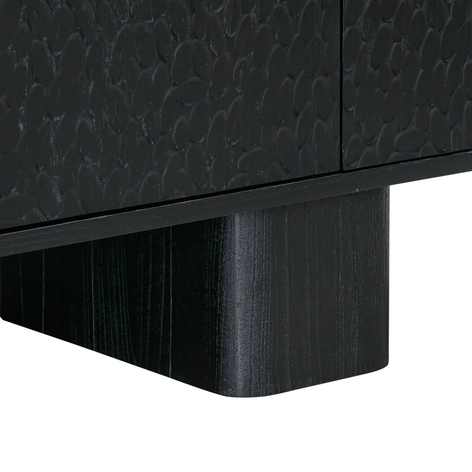 Three-quarter perspective view of the Tonic sideboard featuring a matte black finish with a unique hammered texture on the door panels and chunky block feet
