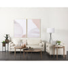 Lifestyle shot featuring the Cleaver nesting tables styled in a bright living room with a white sofa and abstract art