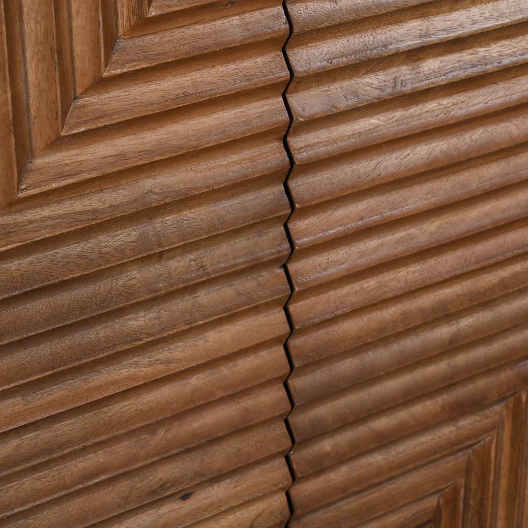 Front view of the Nikita sideboard featuring a warm wood finish with intricate chevron-patterned ribbed door panels and slim black metal legs