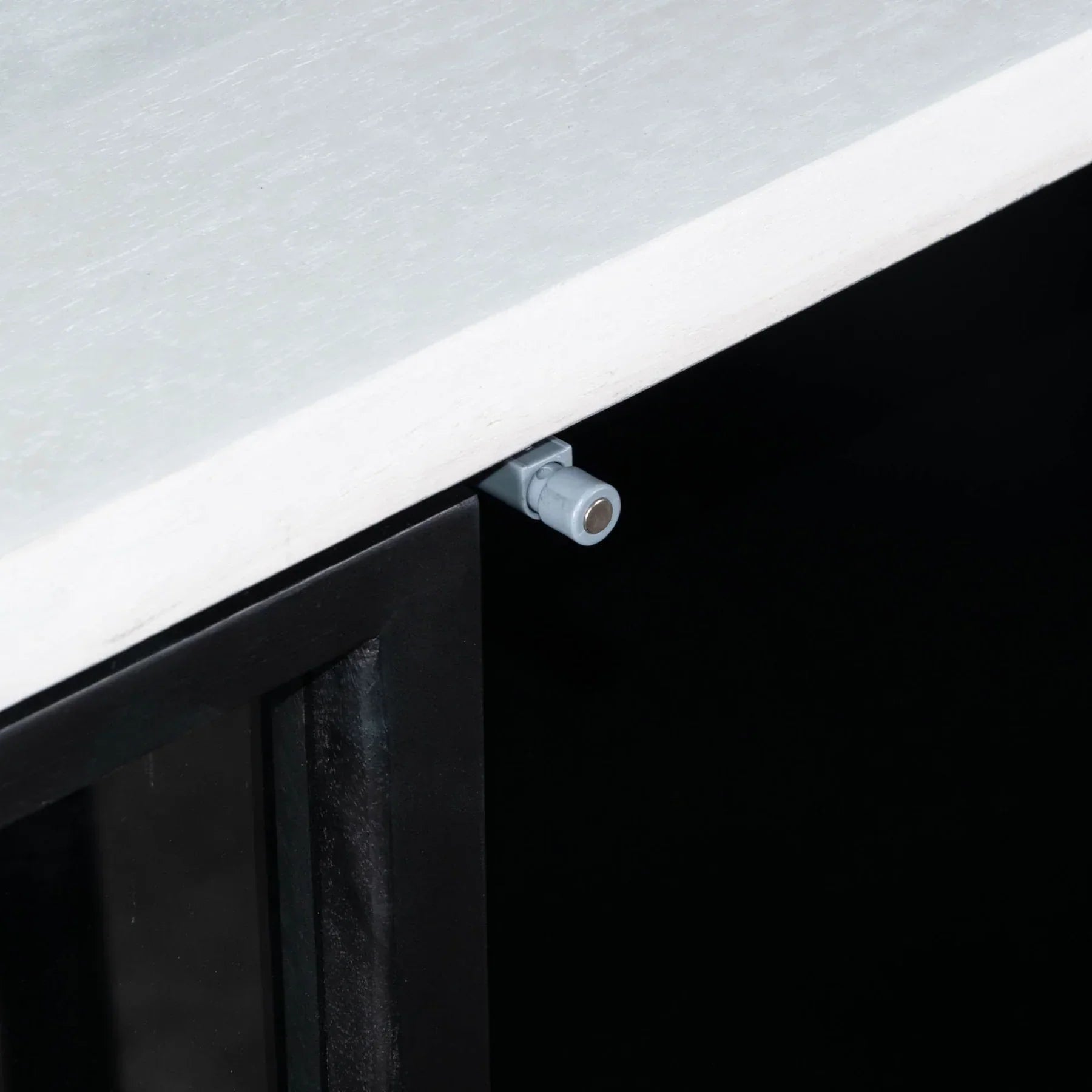 Three-quarter perspective view of the Caged sideboard featuring a sleek white frame, black metal-framed glass doors, and a minimalist black metal base